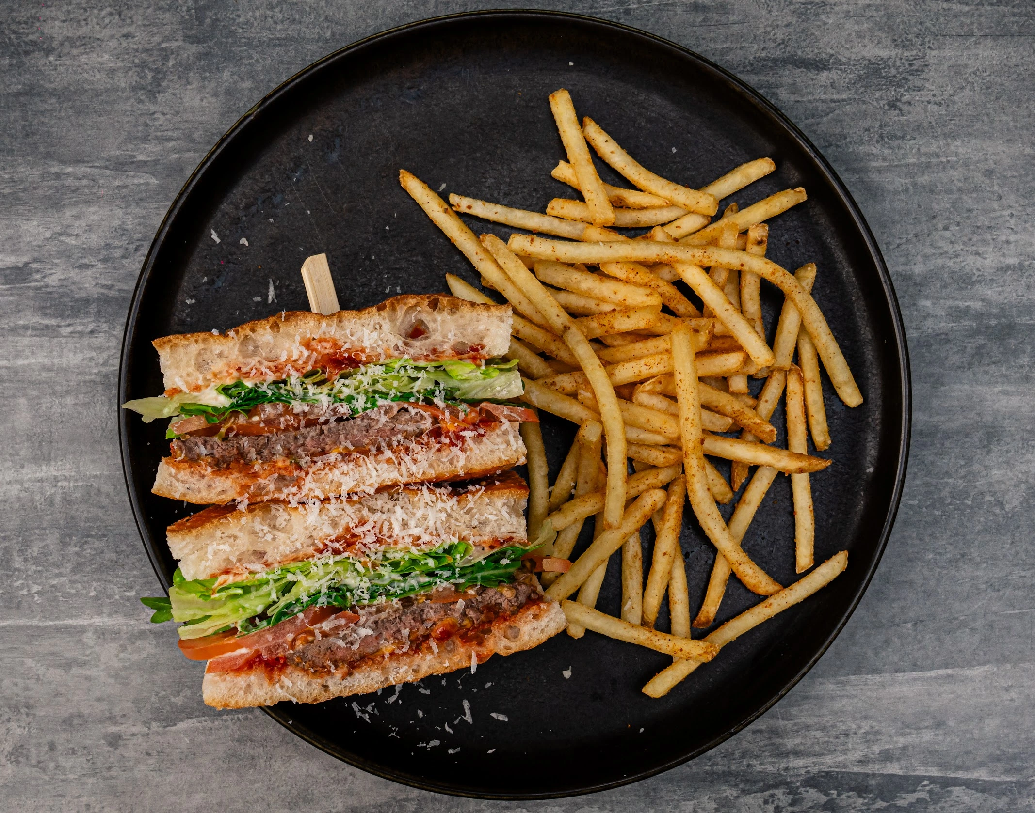 Steak Sanga with minute steak, cos lettuce, rocket, American cheese, caramelised onion, tomato, aioli and crispy fries